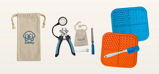 Everything in the Zakity Dog Nail Care Bundle: the Zakity canvas storage bag, the Zakity dog nail clipper with 3x magnifier, magnifier pouch, nail file and tightening wrench, and the orange and blue Zakity lick mats with spatula.